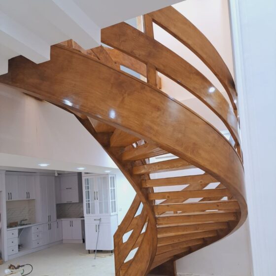 Luxury timber spiral staircase featuring curved balustrades and warm wood finish