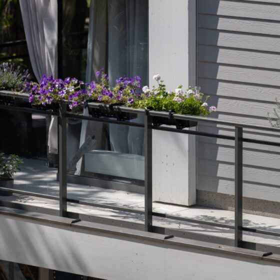 Balcony with steel and glass railing featuring decorative planters