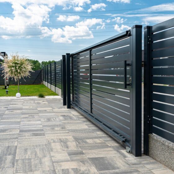 Black sliding metal gate with horizontal lines for modern homes