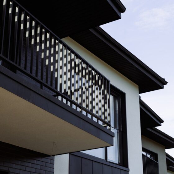 Black steel balcony with decorative vertical railings on residential home