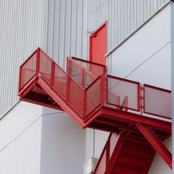 Red steel fire escape staircase with emergency exit door