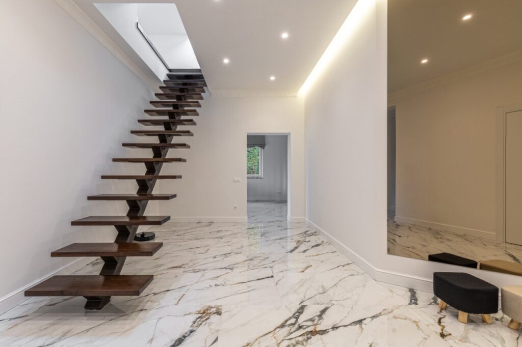 Dark timber floating staircase ideal for contemporary homes with modern marble flooring