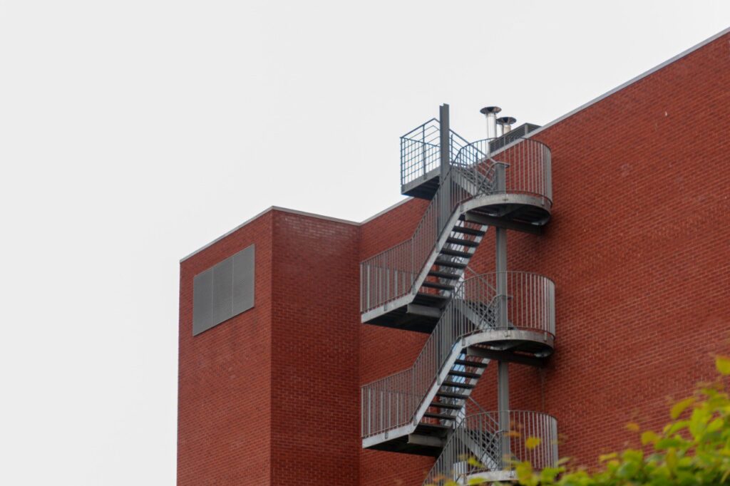 Galvanized steel spiral fire escape staircase on brick building
