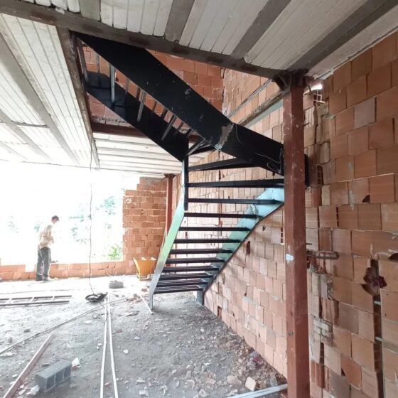 L-shaped steel staircase with landing and open risers on site