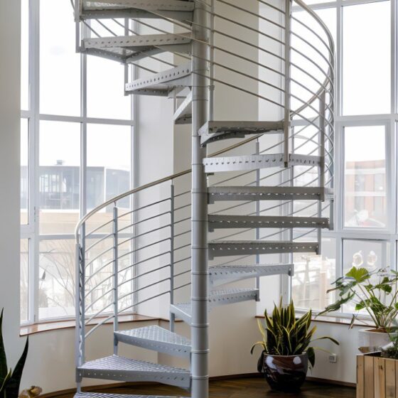 Spiral staircase with steel treads and slim balustrade in a light-filled room
